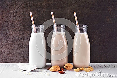 Vegan, plant based, non dairy milk in milk bottles with scattered ingredients Stock Photo