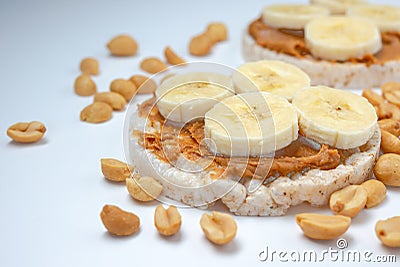 Vegan snacks. Rice cakes with peanut butter sliced banana on white background. High nutrient good sauce of energy healthy snacks a Stock Photo
