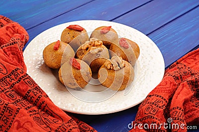 Vegan sweets with wallnuts and goji berries on orange ethnic cloth Stock Photo