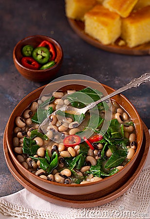 Vegan US southern black-eye peas and collard greens with corn bread in the background Stock Photo