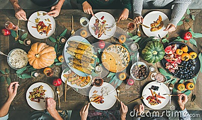 Friends eating at Thanksgiving Day table with vegetarian snacks Stock Photo