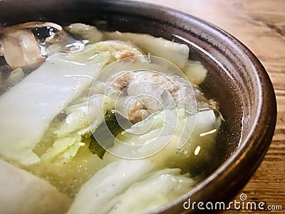 Vege Ball soup in a brown bowl on wooden table. close up view. Stock Photo