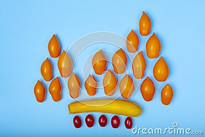 Vegetable concept with orange tomatoes as a fire flame, yellow zucchini and cherry tomatoes. Stock Photo