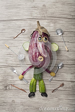 Vegetable figure made on wooden board with kitchen tools Stock Photo