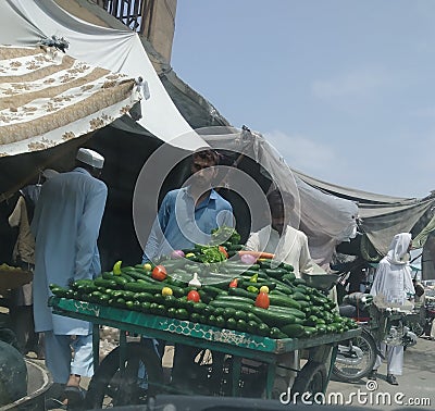 Vegetable market side walk stawl hot summers and decorative cucumbers Editorial Stock Photo