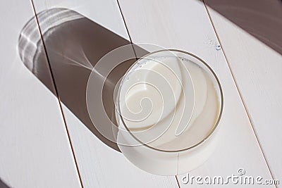 Vegetable milk in a transparent glass on a light wooden background. Stock Photo