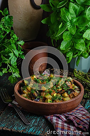 Vegetable roast eggplant and potatoes in a clay plate ketsa. Homemade healthy food in a rustic style Stock Photo