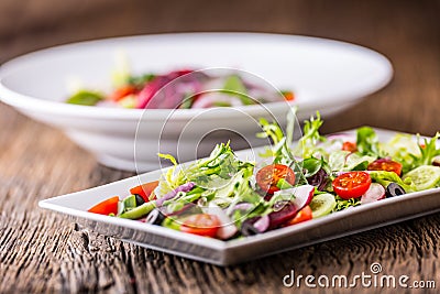 Vegetable salad. Plate of salad with vegetables on rustic oak table. Assortment of ingredients of vegetable salad Stock Photo