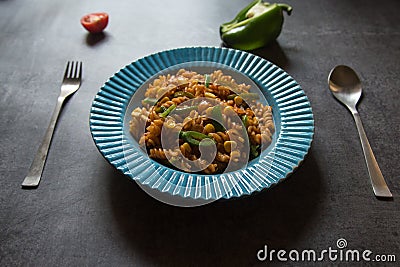 Vegetable spiral pasta served in a blue bowl. Close up. Stock Photo