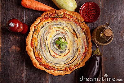 Vegetable Spiral tart with zucchini, eggplant, carrot on wooden background Stock Photo