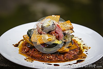 Vegetable stack - pumpkin, zucchini, red capsicum, eggplant and mushroom cooked in a tomato, onion, and garlic sauce topped with p Stock Photo