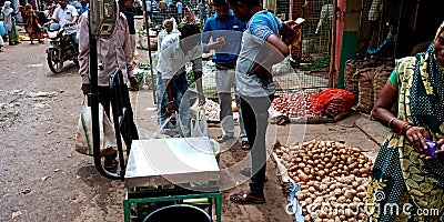 Vegetable vendor measuring goods weight on machine t farmers market Editorial Stock Photo