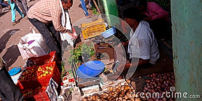 Vegetable vendor measuring goods weight on machine Editorial Stock Photo