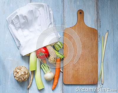 Vegetables in chef's hat and empty cutting board Stock Photo