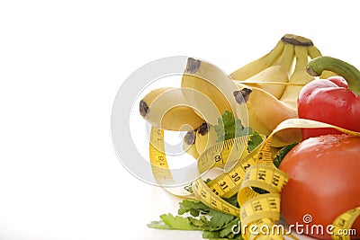 Vegetables, fruits and herbs, measuring tape on a white background, tomato, lemon, lettuce, Apple, pepper, banana Stock Photo