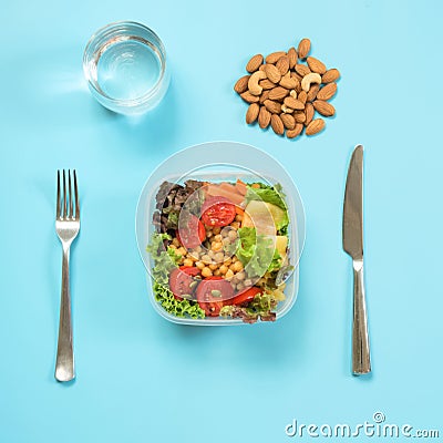 Vegetables healhy salad for office lunch in container on blue table. Concept proper nutrition. Lunchbox. Take away. Stock Photo