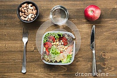 Vegetables salad for office lunch in container on wooden table. Concept healhy nutrition. Lunchbox Stock Photo