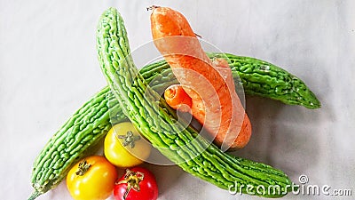 These are vegetables namely carrots, bitter melon and tomatoes Stock Photo