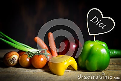 Vegetables on a old wooden table with a heart with word diet Stock Photo