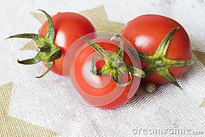 Vegetables on the table, three tomatoes on the white table cloth Stock Photo