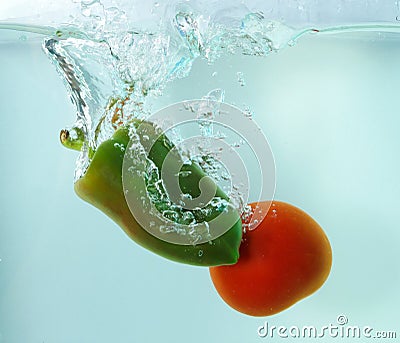 Vegetables tomato and paprika in water splash on blue background Stock Photo