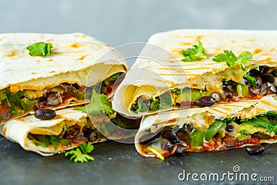 Vegetarian burritos wraps with beans, avocado and cheese on a slate Stock Photo