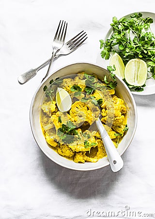 Vegetarian cauliflower curry sauce, cilantro, lime on light background, top view. Delicious indian food Stock Photo
