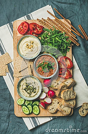 Vegetarian dips hummus, babaganush, muhammara on wooden board Stock Photo