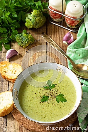 Delicious broccoli cream soup served with garlic croutons on a rustic table. Copy space Stock Photo
