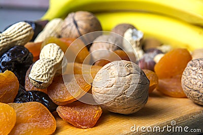 Vegetarian food of nuts and dried fruits on the kitchen board Stock Photo