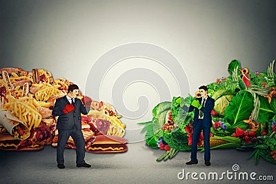 Vegetarian food representative fighting unhealthy junk fatty food guy with boxing gloves Stock Photo