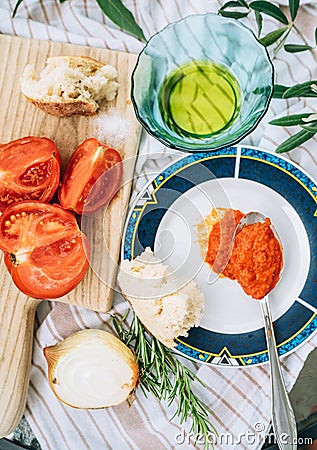 Vegetarian low-calorie still life with red tomatoes ,olive oil, garlic, onion and big spoon of AJVAR - traditional Balkans Stock Photo