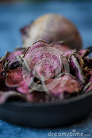 Vegetarian pile of healthy beet chips Purple Baked Beet Chips Vegan snacks, vegetable chips in canvas bag and ceramic bowl, rustic Stock Photo