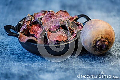 Vegetarian pile of healthy beet chips Purple Baked Beet Chips Vegan snacks, vegetable chips in canvas bag and ceramic bowl, rustic Stock Photo