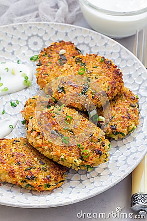 Vegetarian quinoa, carrot, coriander and green onion fritters served with yogurt, vertical Stock Photo