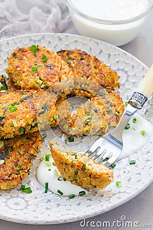 Vegetarian quinoa, carrot, coriander and green onion fritters with yogurt on plate, vertical Stock Photo