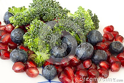 Vegetarian raw food. Salad of broccoli, pomegranate seeds and blueberries a variety of nutrients. Extreme close-up with selective Stock Photo