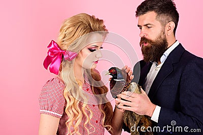 Vegetarian. retro happy woman and man hold pheasant. Crazy couple on pink. Halloween. Creative idea. Bird flu. Funny Stock Photo