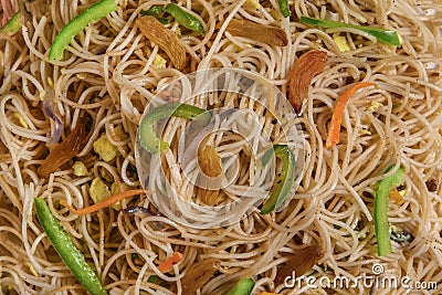 Vegetarian Schezwan Noodles or Vegetable Hakka Noodles or Chow Mein in white plate at wooden background. Schezwan Noodles is indo- Stock Photo