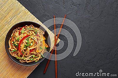 Vegetarian Schezwan Noodles or Vegetable Hakka Noodles or Chow Mein in black bowl at dark background. Indo-chinese cuisine hot Stock Photo