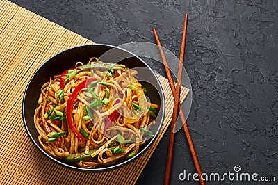 Vegetarian Schezwan Noodles or Vegetable Hakka Noodles or Chow Mein in black bowl at dark background. Indo-chinese cuisine hot Stock Photo