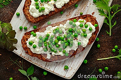 Vegetarian seeded sourdough bread open sandwich with cottage cheese and petit poit peas sprinkled with chilli flakes Stock Photo