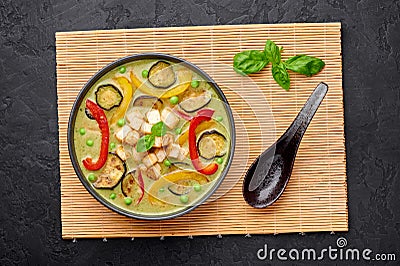 Vegetarian Thai Green Curry with tofu in black bowl at dark slate background. Thailand cuisine dish. Thai Food Stock Photo
