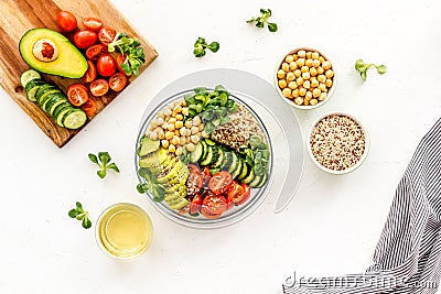 Veggie bowl. Vegetable salad with quinoa, avocado, tomato, spinach and chickpeas - on white table. Top view Stock Photo