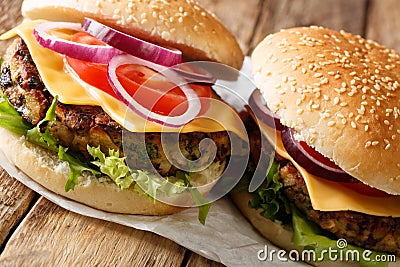 Veggie burger with fresh lettuce, onions, tomatoes and cheddar cheese close-up. horizontal Stock Photo