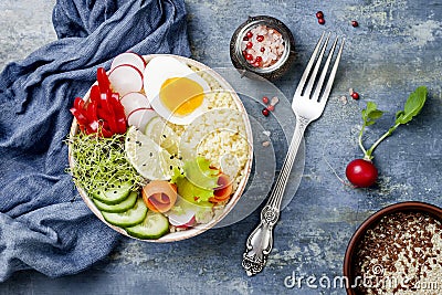Veggies detox Buddha bowl recipe with egg, carrots, sprouts, couscous, cucumber, radishes, seeds. Top view, flat lay, copy space Stock Photo