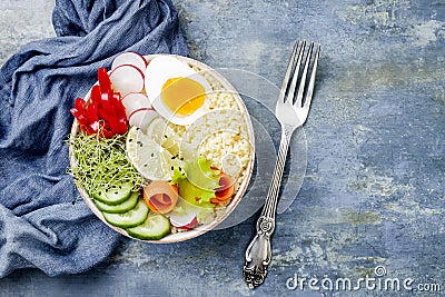 Veggies detox Buddha bowl recipe with egg, carrots, sprouts, couscous, cucumber, radishes, seeds. Top view, flat lay, copy space Stock Photo