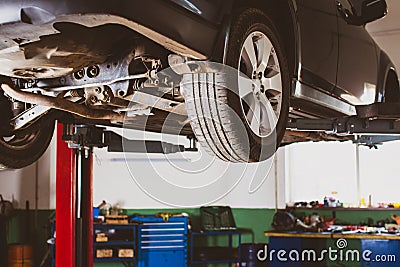 Vehicle raised on lift at maintenance station Stock Photo