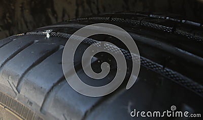 Screw sticks out of vehicle tire Stock Photo