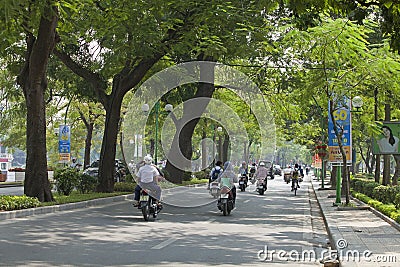 Vehicles traveling on a green street of Hanoi capital Editorial Stock Photo